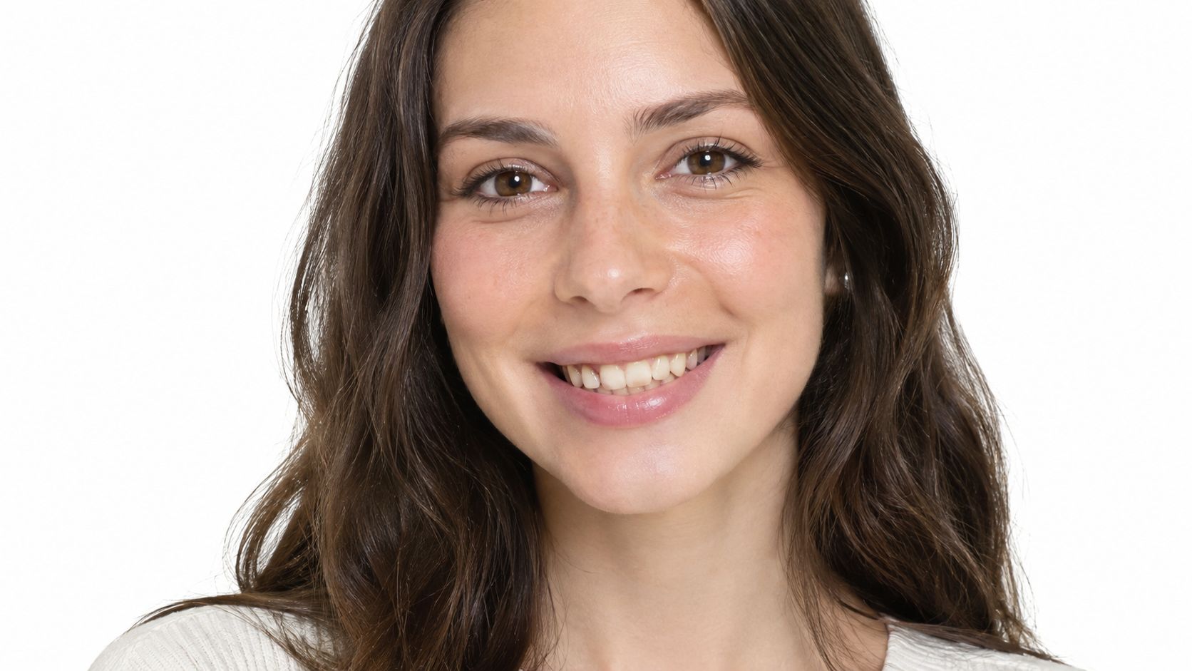 A close-up portrait of a smiling woman with natural brown hair against a simple white background.